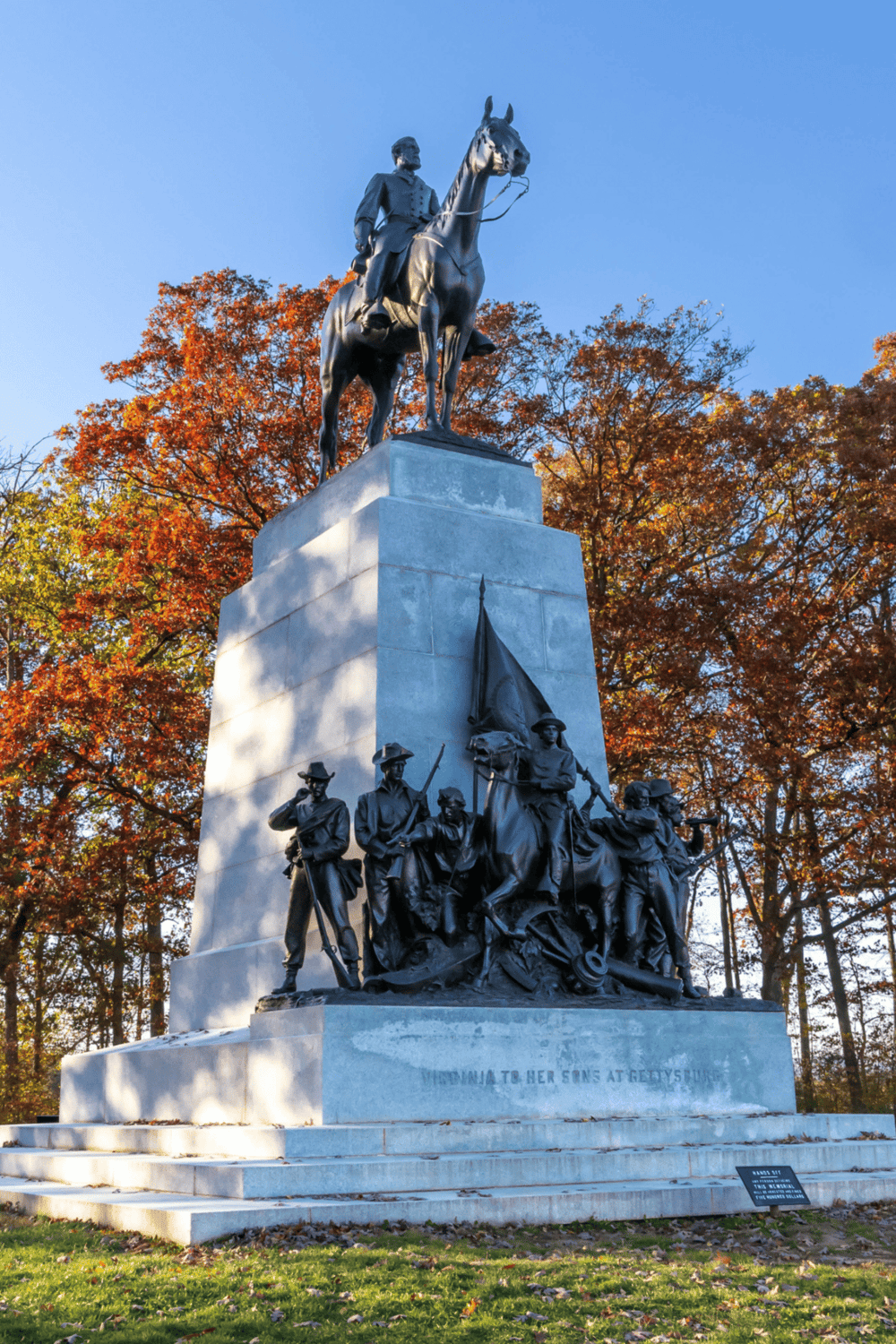 Statue of Civil War soldiers and a mounted Union soldier, memorial honoring fallen heroes, beautiful autumn background.