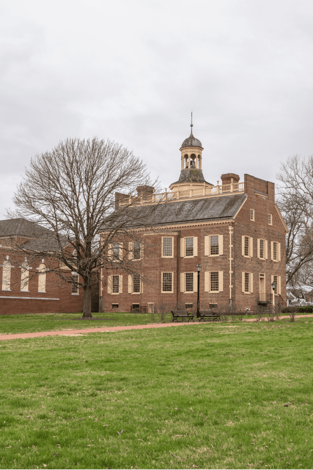 1. Historic brick building with classical architecture and a central tower 2. Traditional brick courthouse with clock tower and surrounding park 3. Picturesque historic courthouse featuring a brick facade, tower, and well-maintained park area.