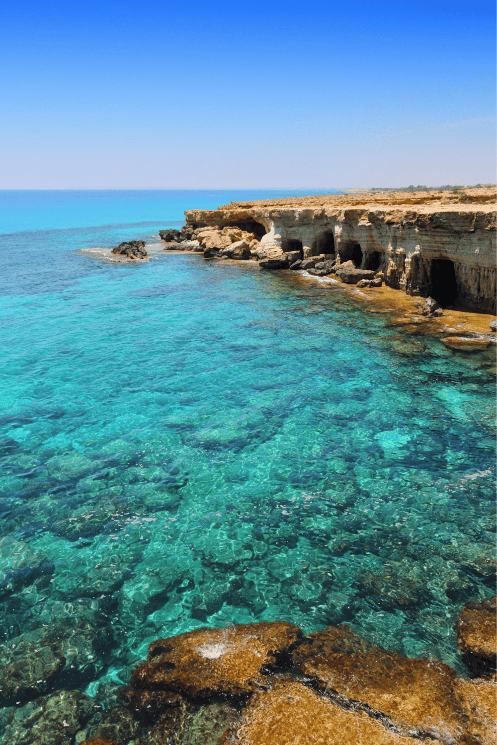 Rocky coastline with clear turquoise waters and rugged cliffs.