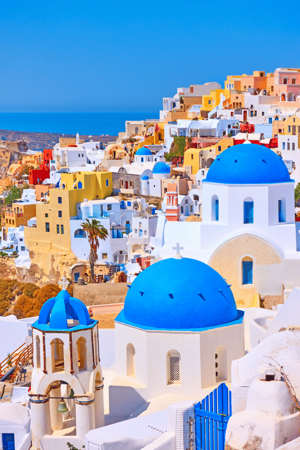 Colorful Santorini village with white buildings and blue domes, popular travel destination in Greece.