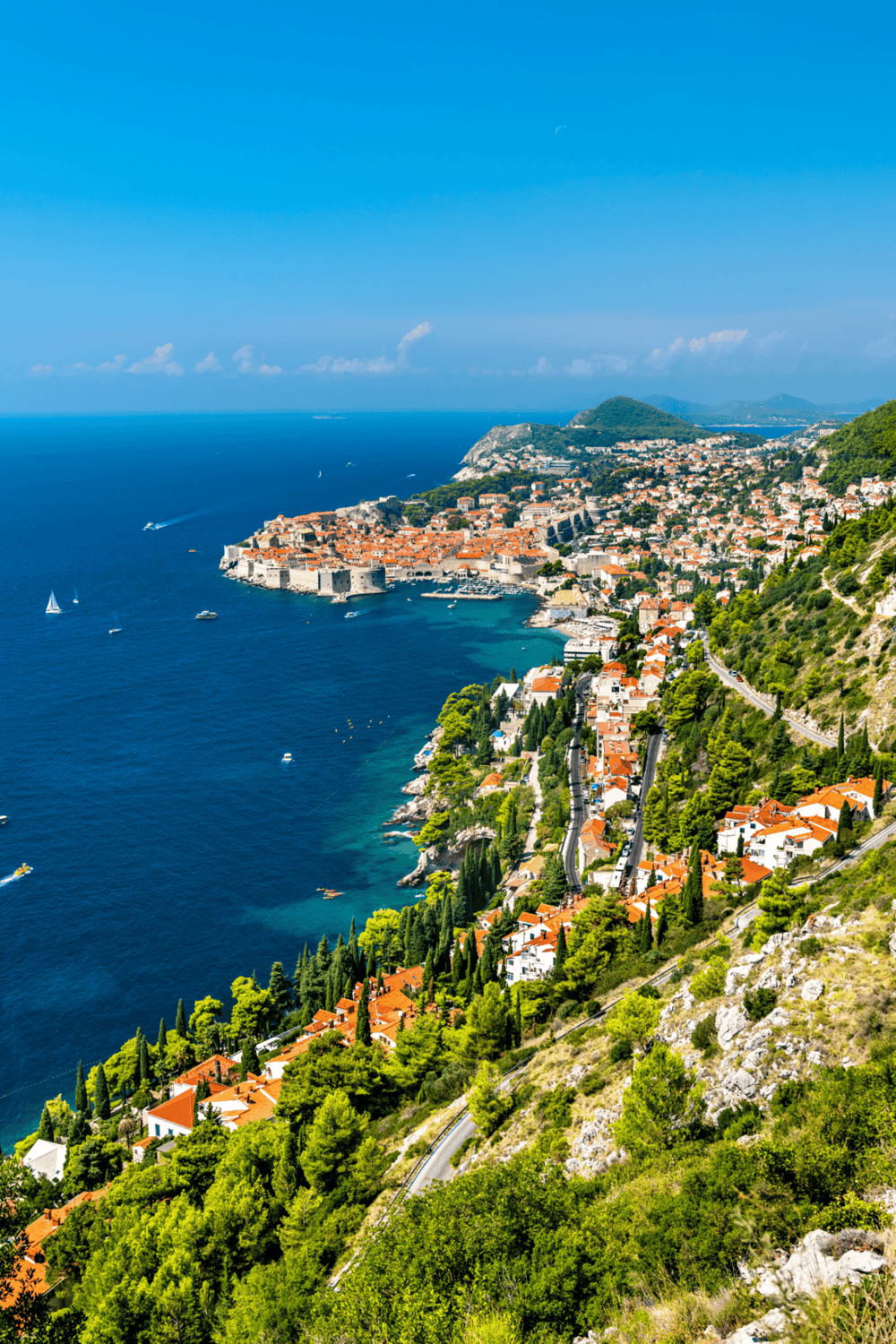 Vivid coastal cityscape of Dubrovnik, Croatia with historic walls, red-tiled roofs, and turquoise waters, ideal for travel and adventure.