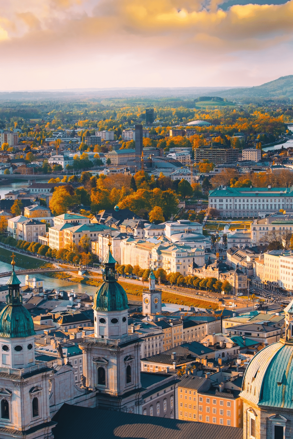 Ancient cityscape featuring historic architecture, river views, and lush green parks in a vibrant urban setting.