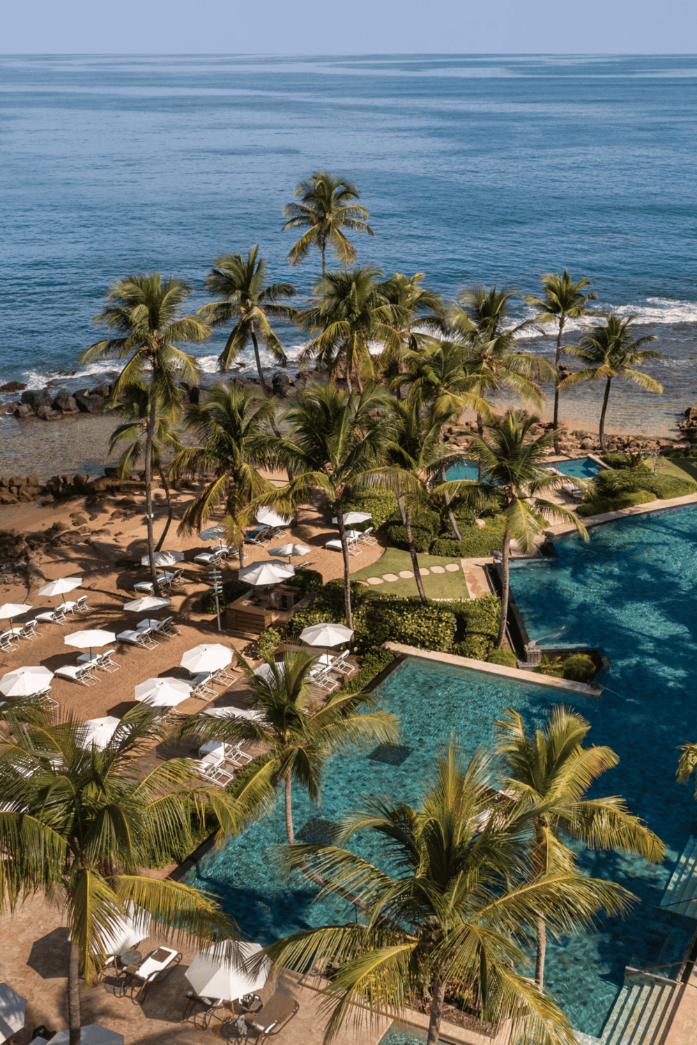 Luxurious oceanfront resort with infinity pools, palm trees, and scenic beach views | Quest For Directions.