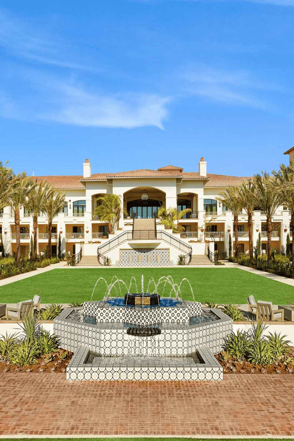 Luxurious hotel with palm trees, fountain, and modern architecture | QuestForDirections.