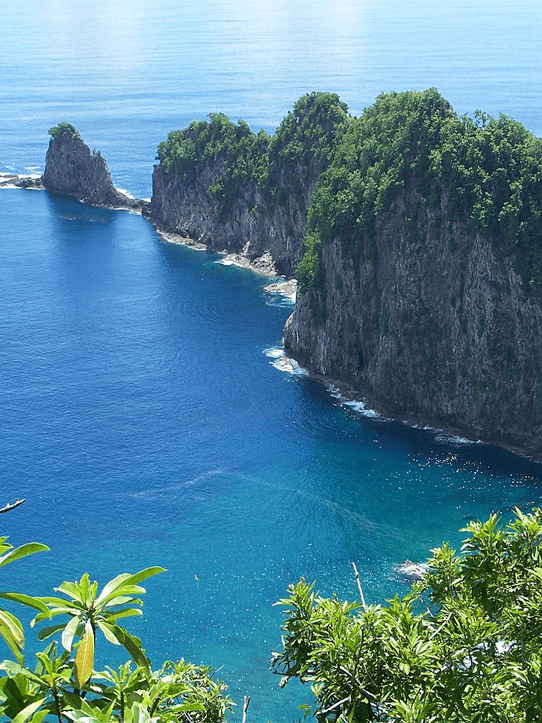 Spectacular view of lush green cliffs and vibrant blue ocean at QuestForDirections location.
