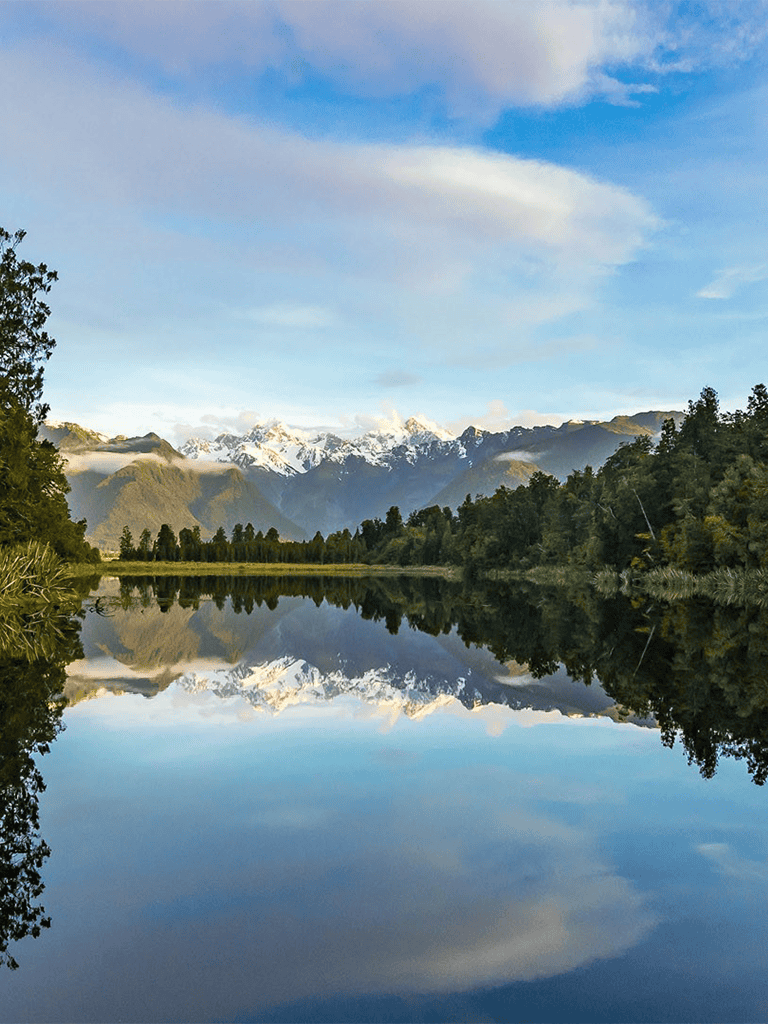 Serene mountain lake with snow-capped peaks and reflection, exploring QuestForDirections travel destinations.