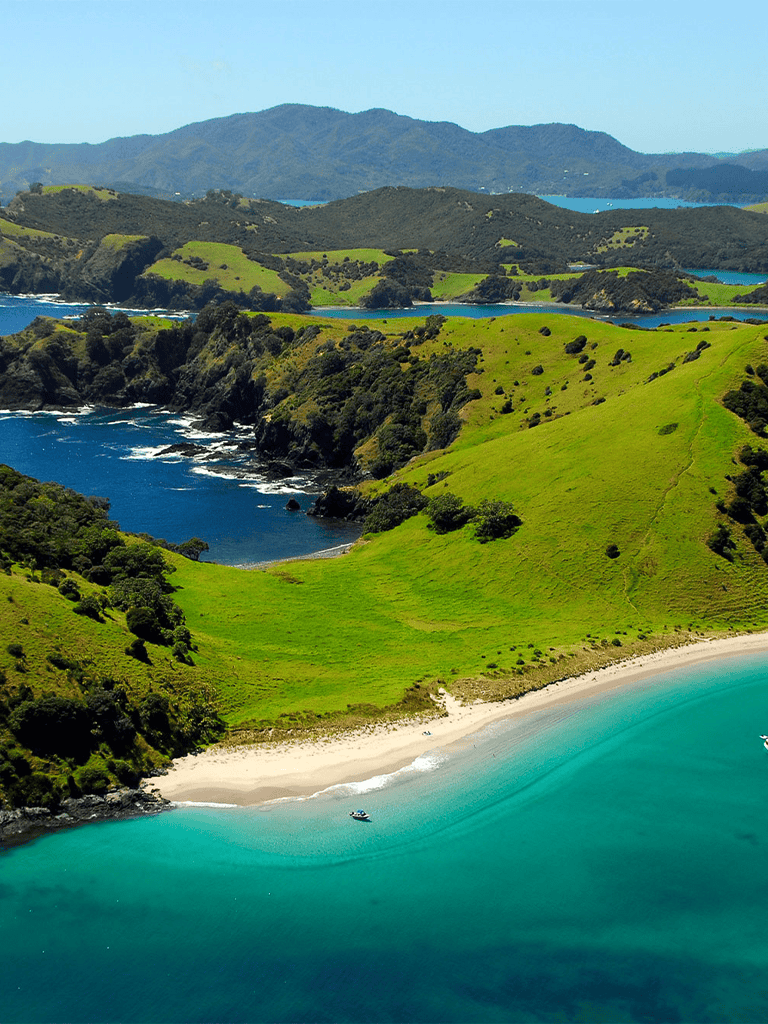 Pristine coastal landscape with green hills, sandy beach, and turquoise waters, perfect for travel planning.