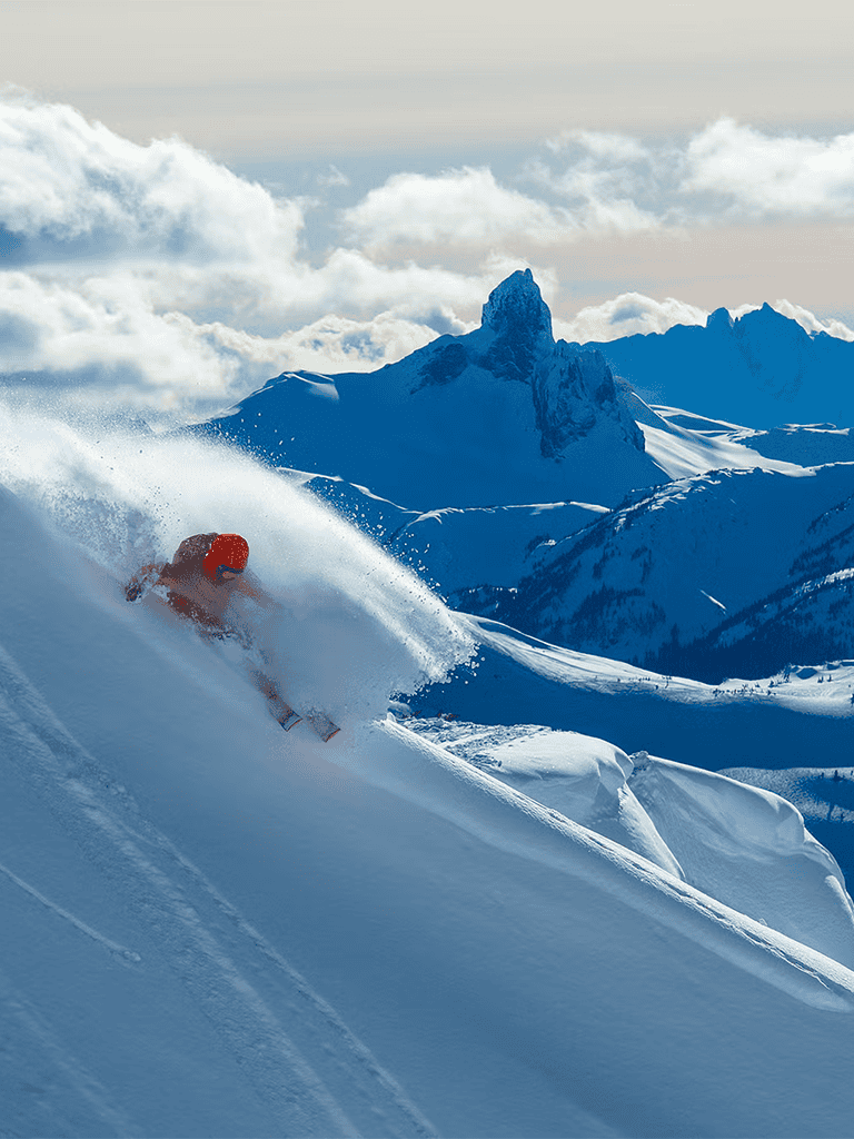 Stunning mountain skier carving through deep snow on a vibrant winter day.