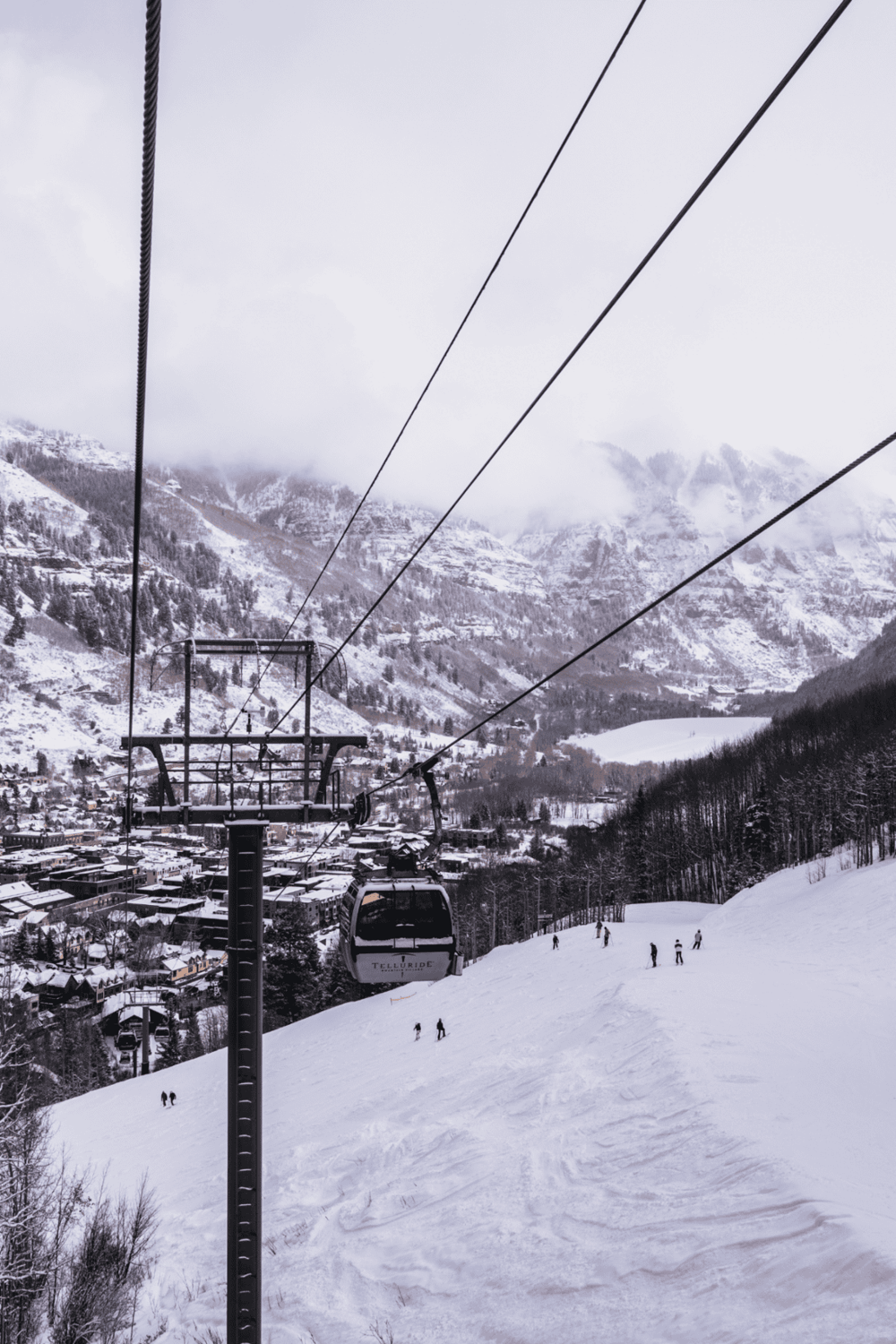 Snowy mountain ski resort with gondola lift and skiers, winter outdoor adventure destination.