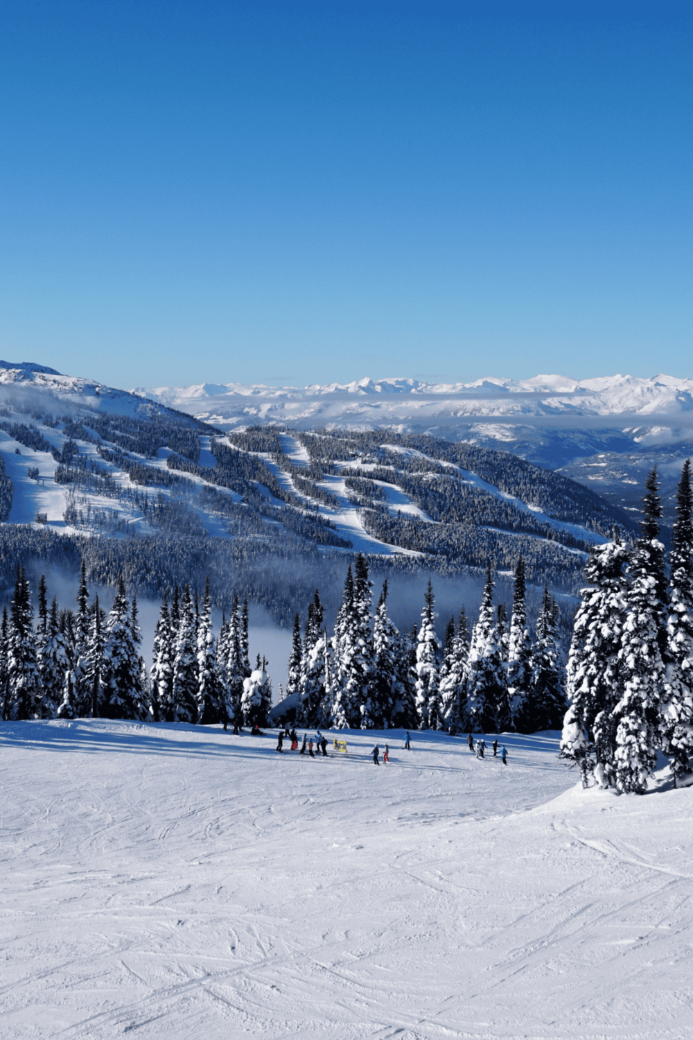 Snowy mountain landscape with ski slopes and skiers, scenic winter outdoor recreation.