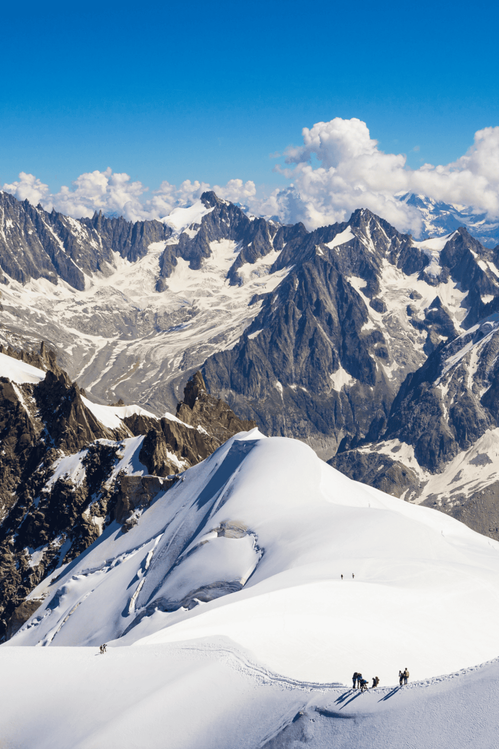 Snow-capped mountain range with hikers on the trail, scenic outdoor adventure at QuestForDirections.