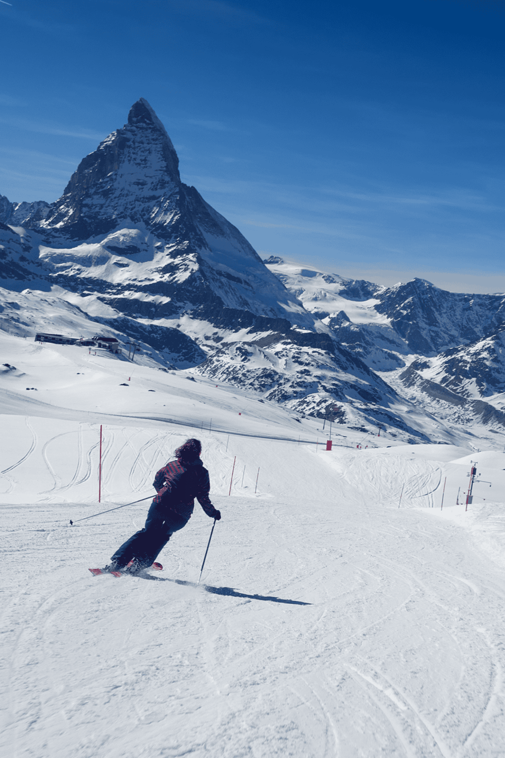 Snow-capped mountain landscape with skier on slopes in Switzerland.
