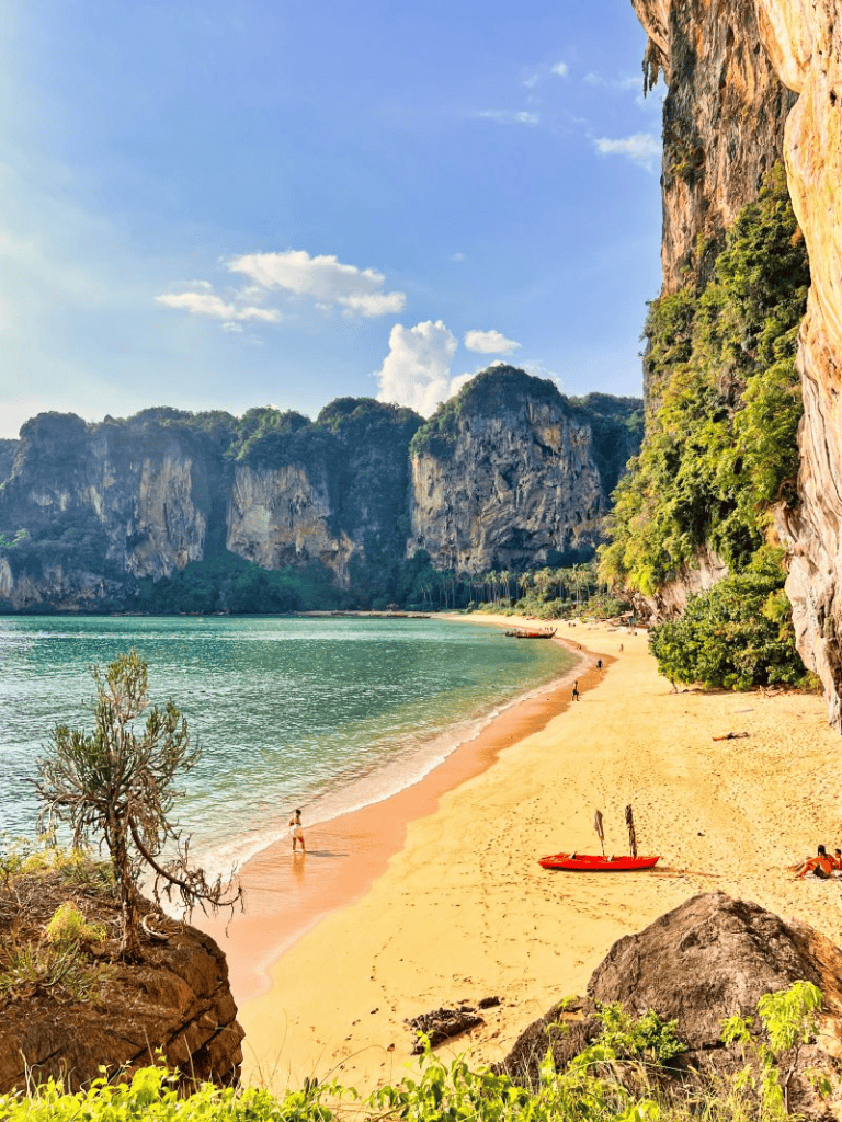 Breathtaking tropical beach with limestone cliffs, turquoise water, and golden sands in Phuket, Thailand.
