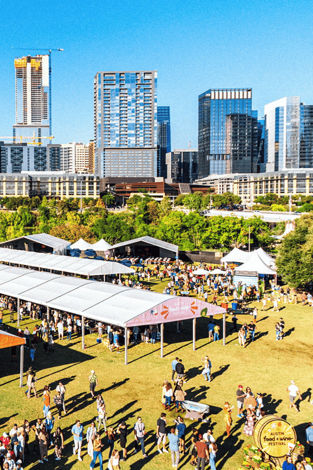 Vibrant city skyline with outdoor festival, food tents, and green spaces in Austin, Texas.