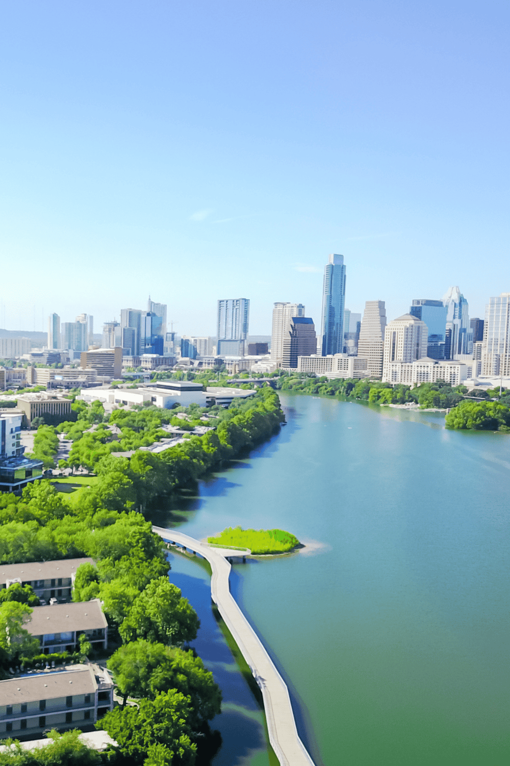 Vibrant city skyline with lush green riverfront and modern buildings, ideal for navigation and city exploration.