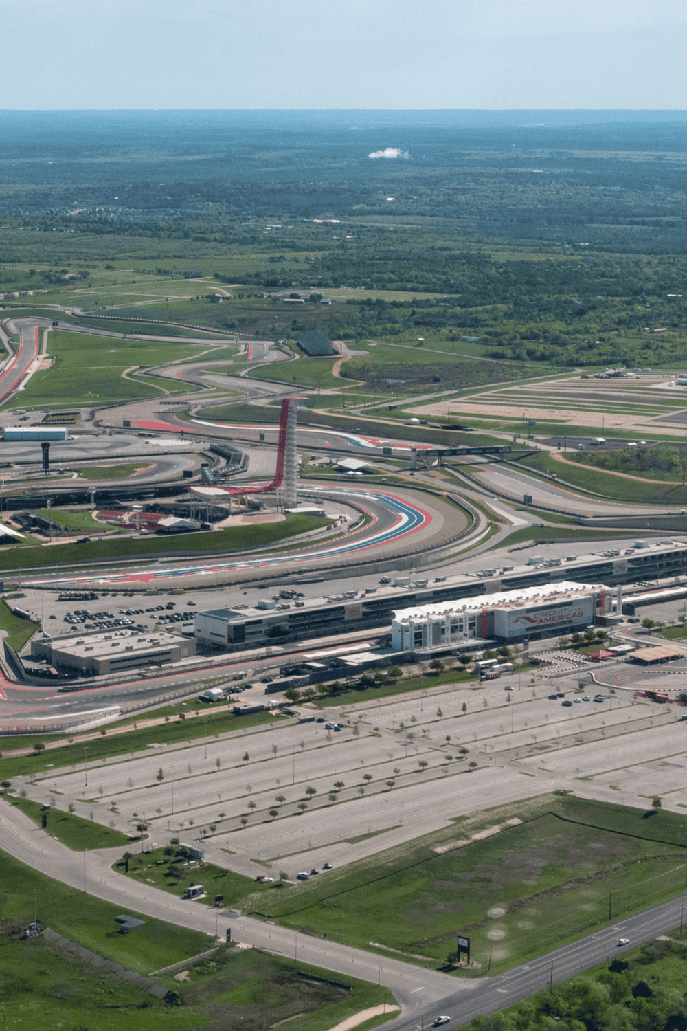 Aerial view of Circuits of Americas race track with surrounding parking lots and greenery.