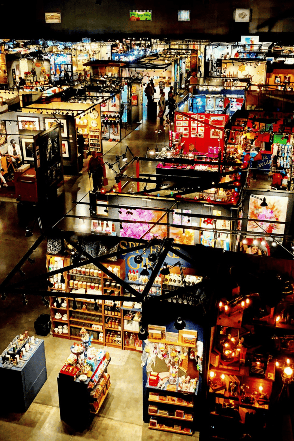 Bright indoor craft fair with colorful booths and shoppers browsing unique handmade items.
