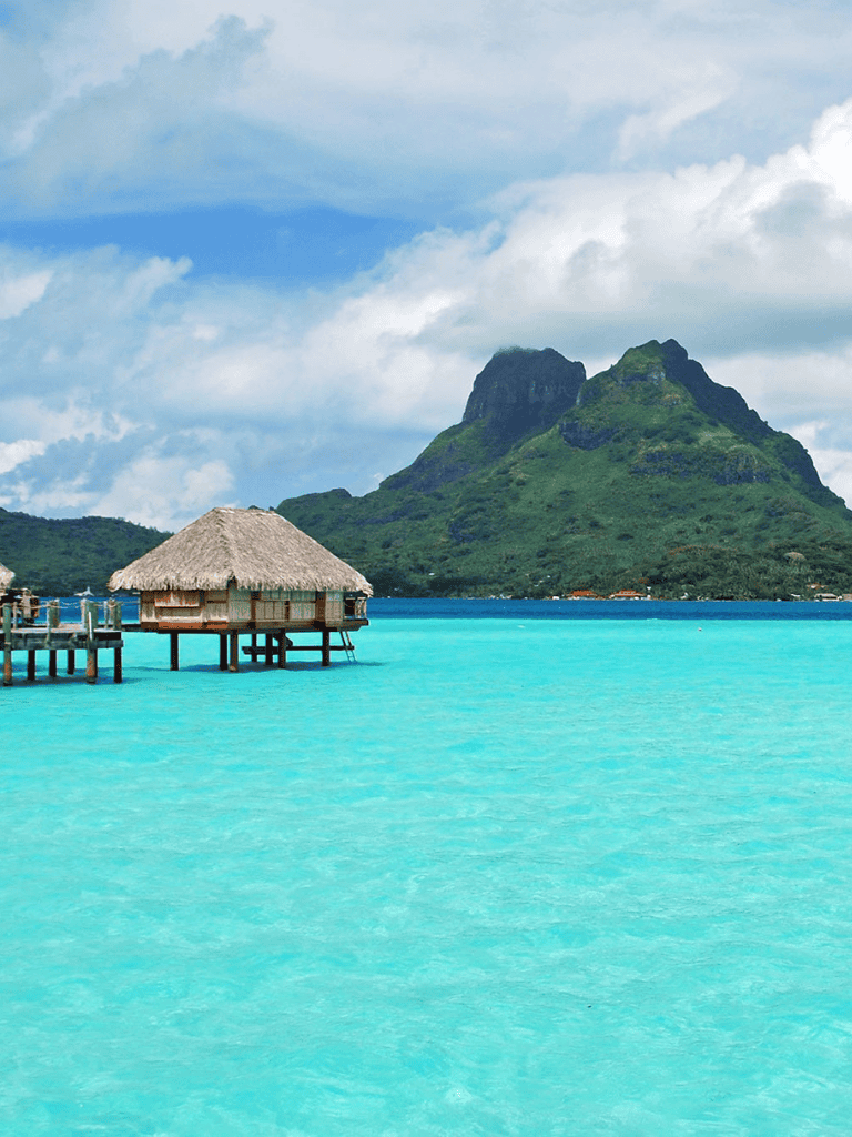 Pristine turquoise waters with overwater bungalow in Bora Bora, Polynesia.
