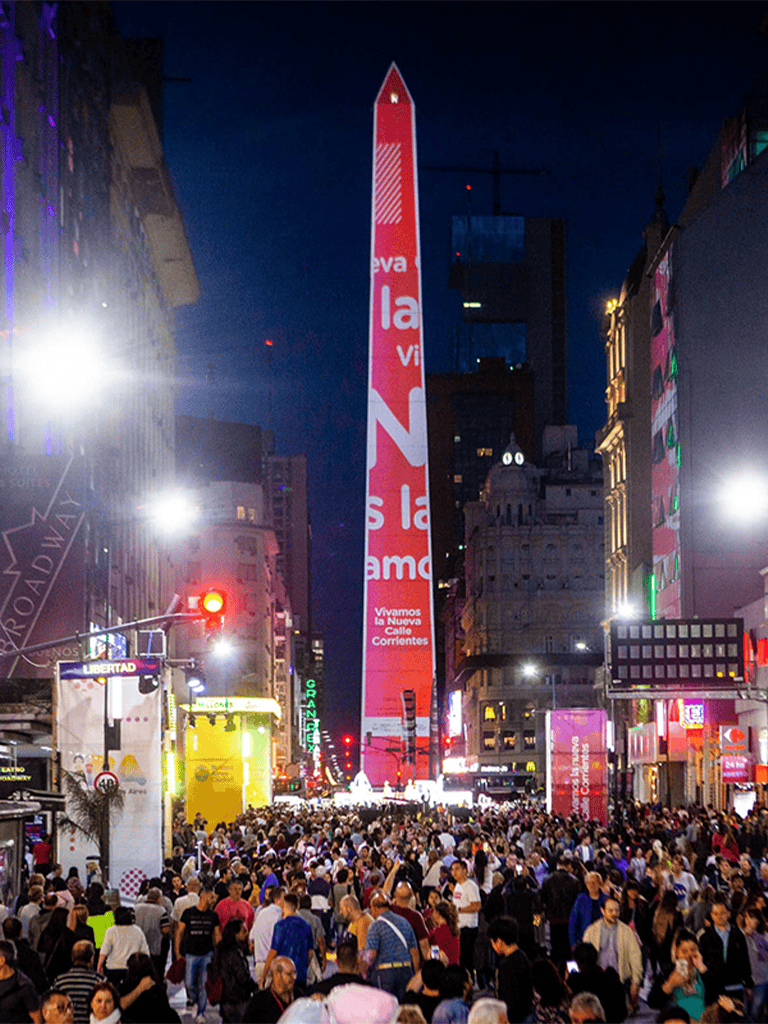 Vibrant night scene of Times Square with crowds, bright billboards, and illuminated buildings in New York City.