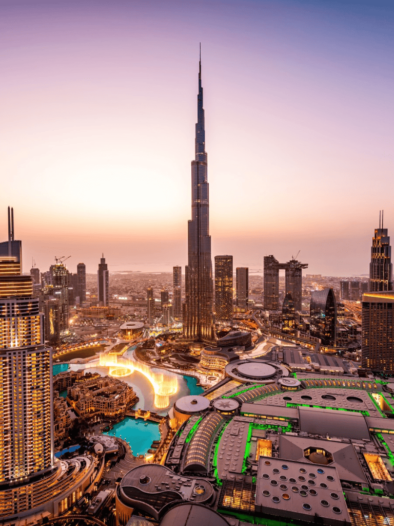 Burj Khalifa Dubai skyline at sunset with city lights.