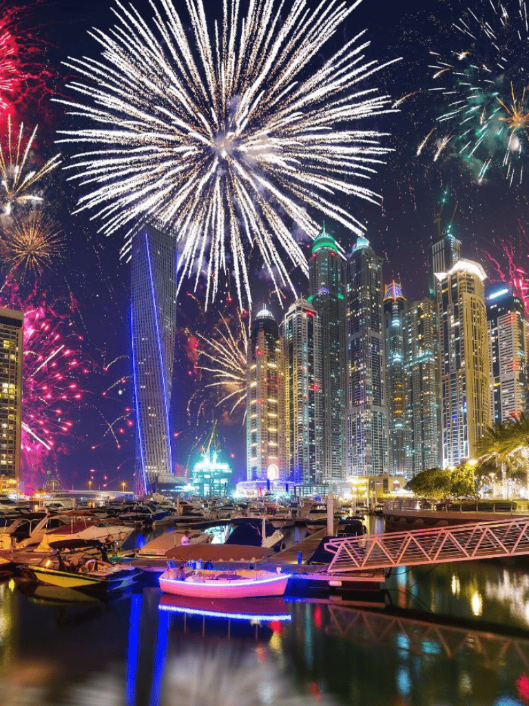 Colorful fireworks over a city skyline with boats, celebrating New Year's eve in a vibrant metropolis.