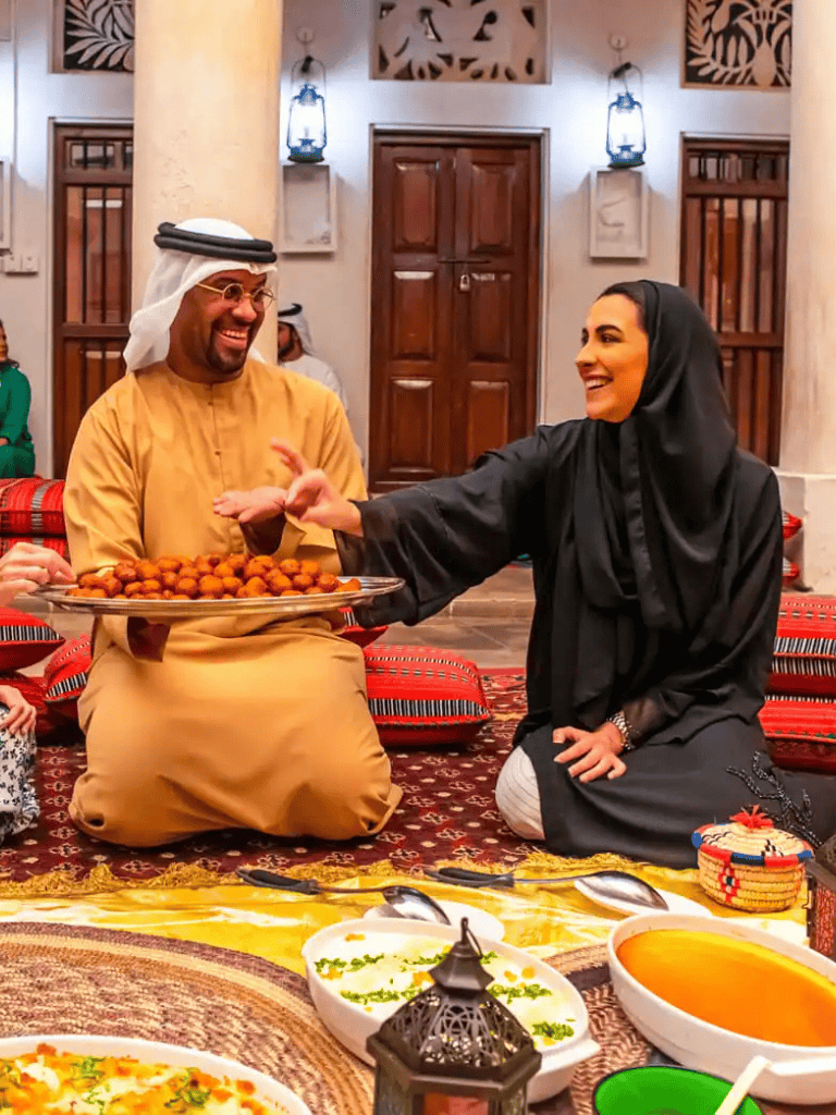 1. Traditional Middle Eastern hospitality with smiling hosts sharing a tray of delicious food.