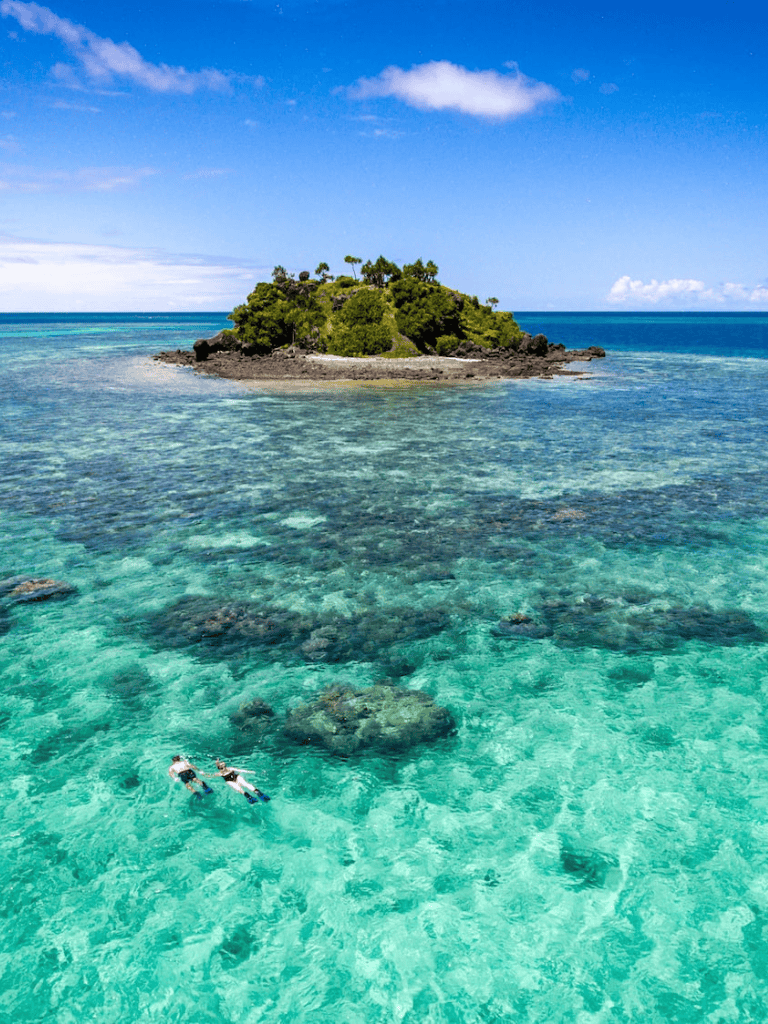 Secluded tropical island with clear turquoise waters and lush greenery, perfect for island adventures and relaxation.