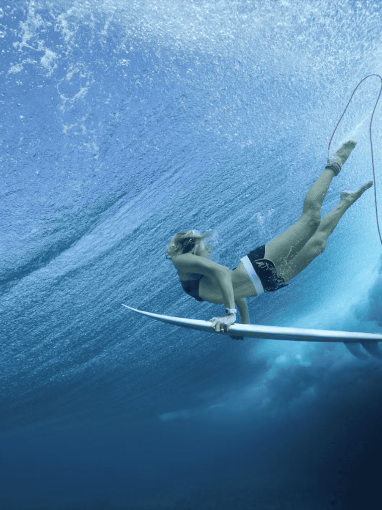 Underwater surfer with surfboard in deep blue ocean, extreme sports adventure.