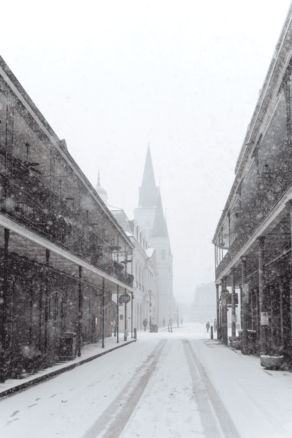 Snow-covered historic street with church spire, scenic winter cityscape, and vintage buildings, perfect for travel and navigation.