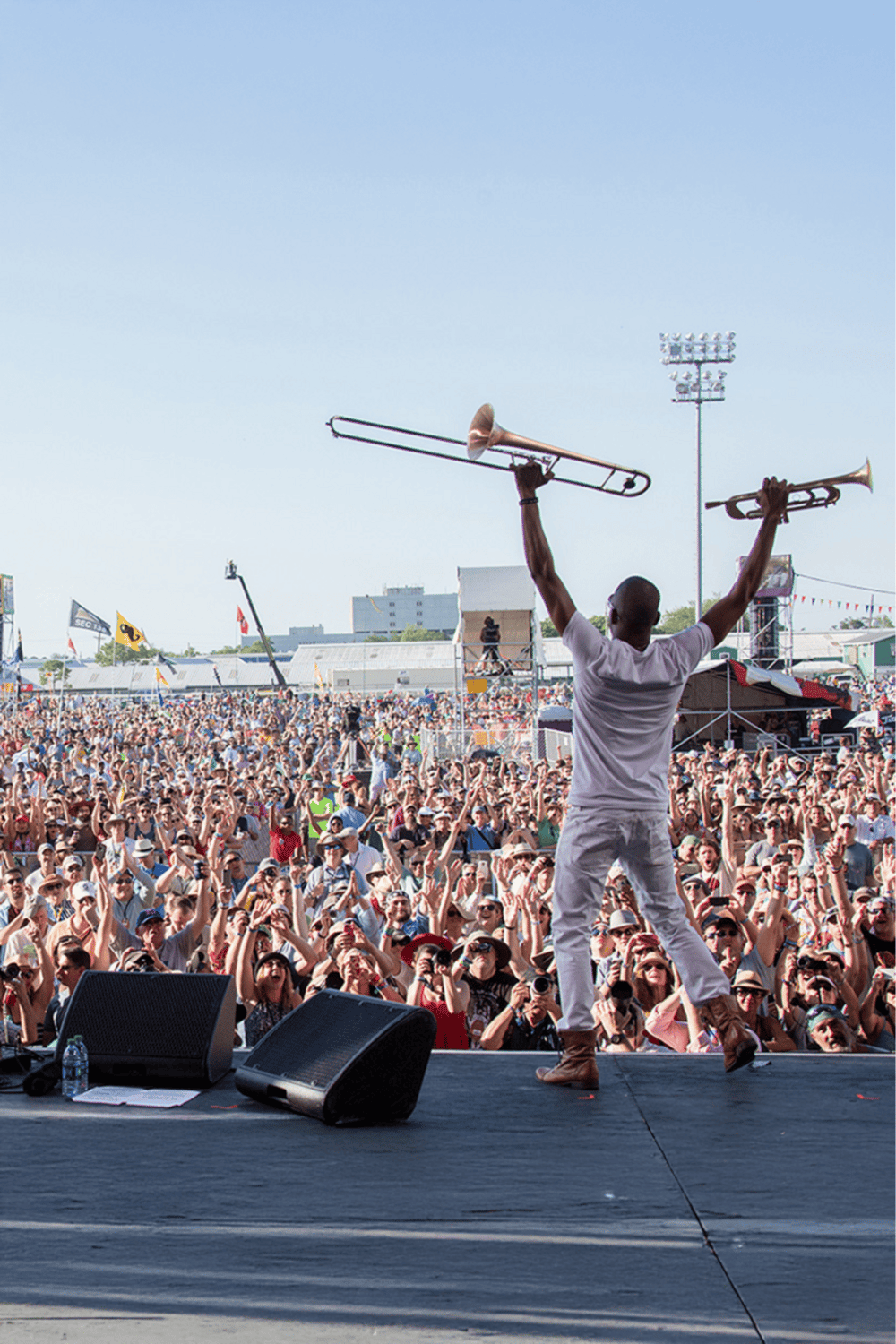 Energetic performer on stage at a music festival with a large crowd, emphasizing concert and event navigation.