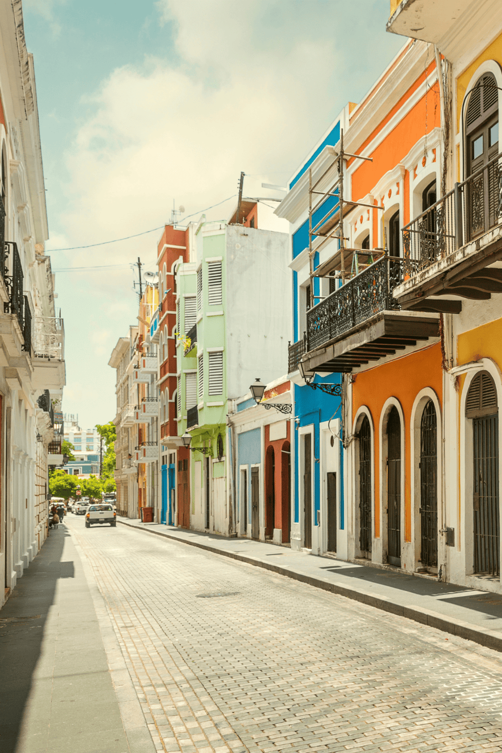 Colorful historic buildings on a vibrant city street with cobblestone pavement and classic architecture.