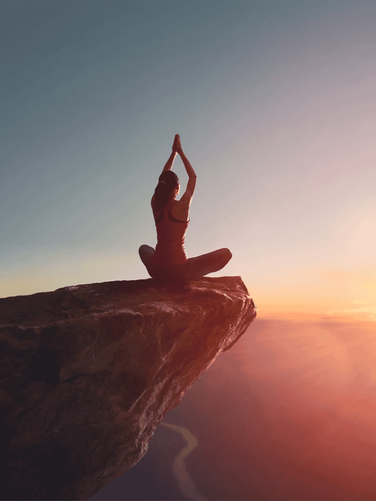 Peaceful woman practicing yoga on mountain cliff at sunrise for mindfulness and wellness.