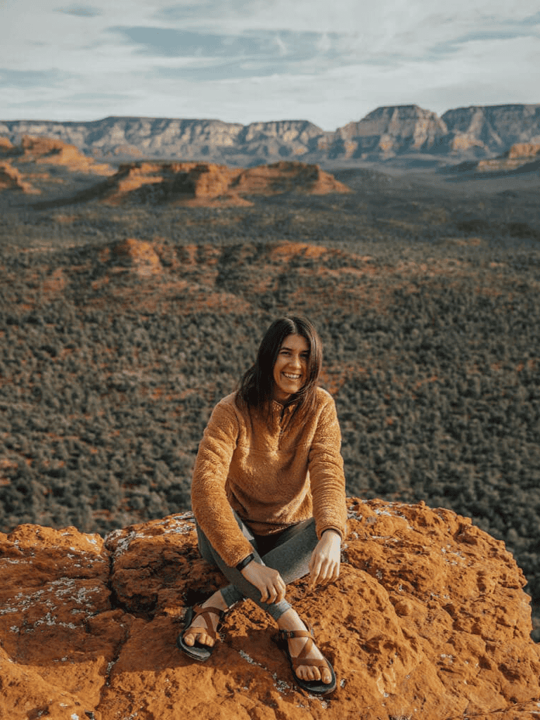 Stunning woman hiking at Grand Canyon during sunset, enjoying nature and outdoor adventure in Arizona.