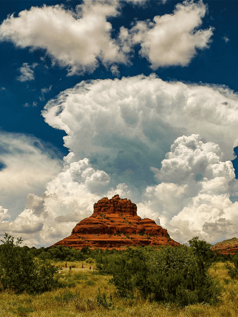 Red rock formation in desert landscape under dramatic cloudy sky, Scottsdale, Arizona.