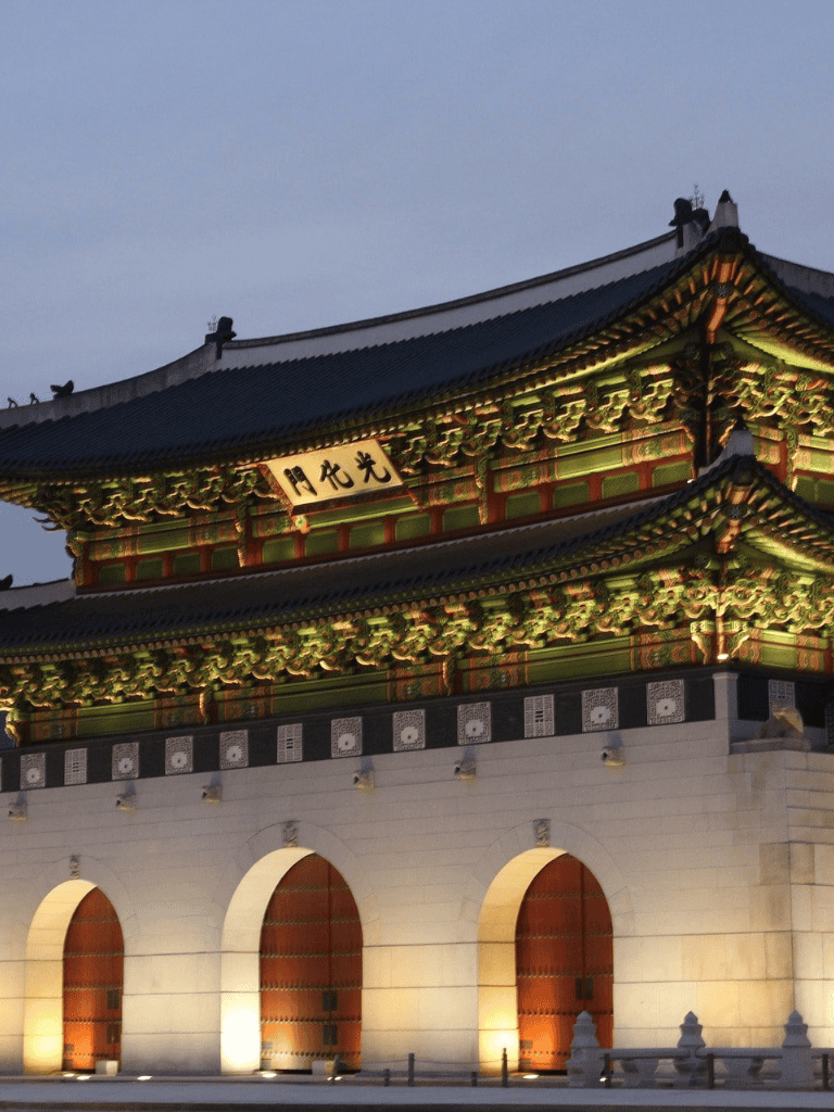 Ancient Korean palace illuminated at dusk, rich in traditional architecture and historical significance.