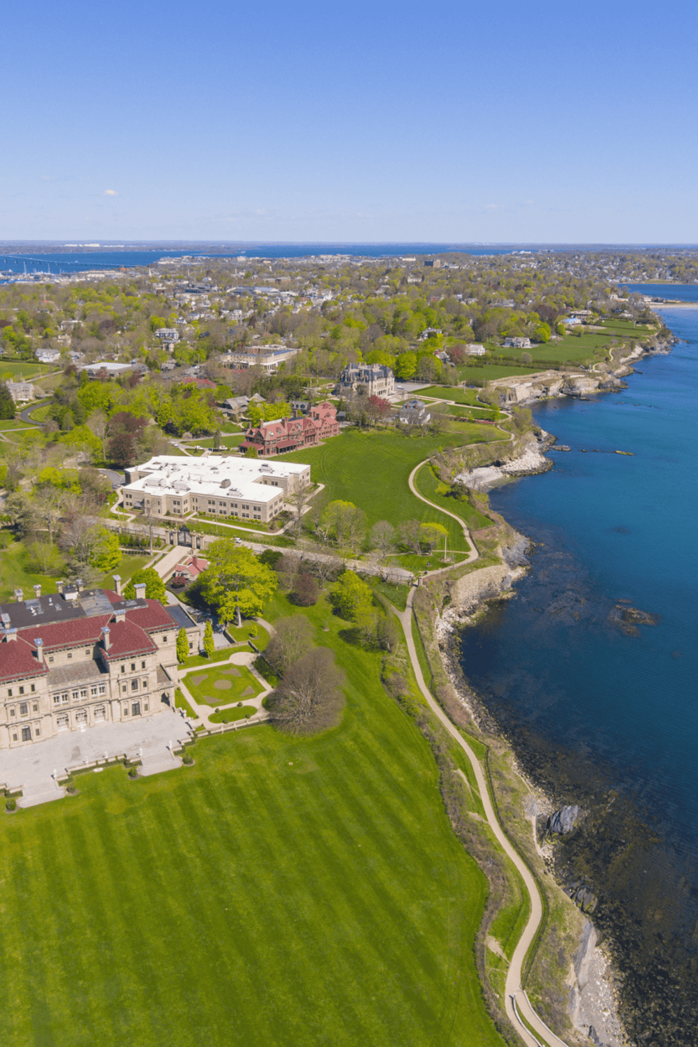 Panoramic aerial view of historic mansion and lush greenery along the scenic coastline in Connecticut.