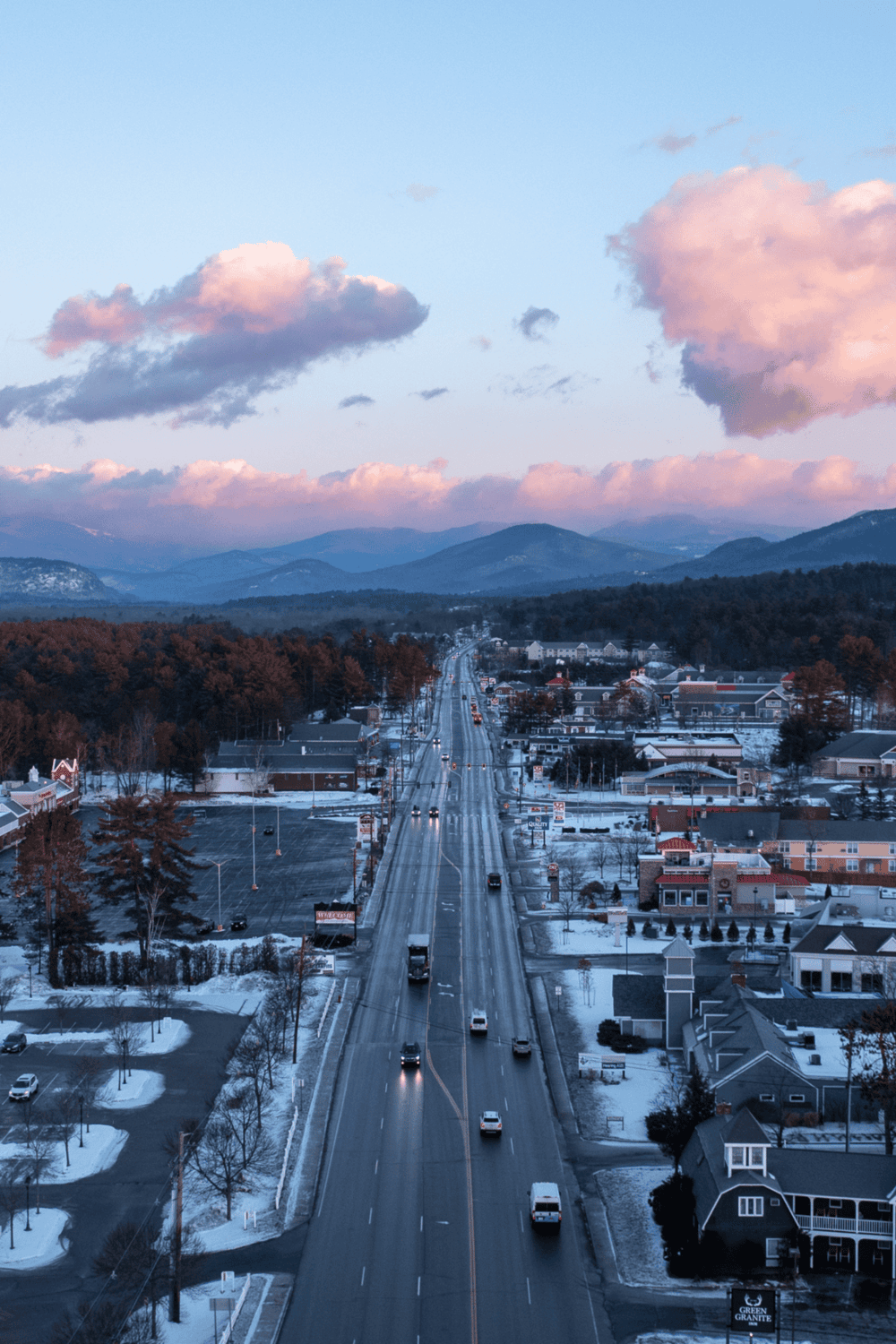 Scenic mountain town view with downtown streets, snow patches, and mountain backdrop during winter.