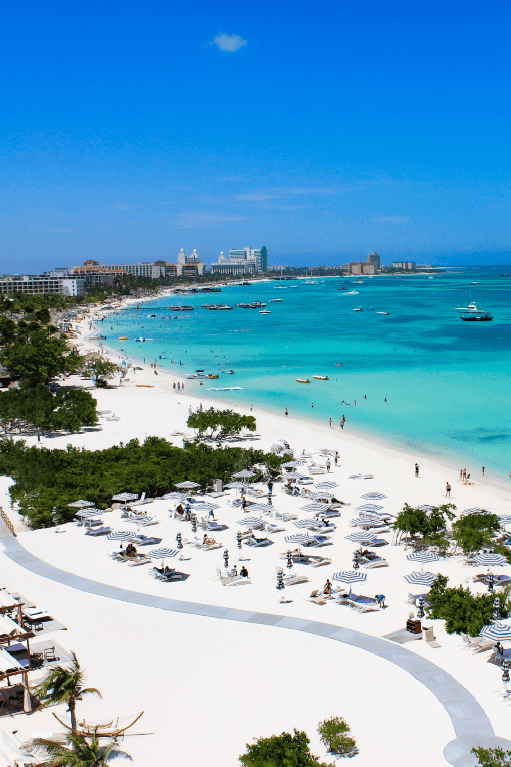 Bright sunny beach in Cancun with turquoise water, white sand, and hotels in the background. Perfect for travel and vacation planning.