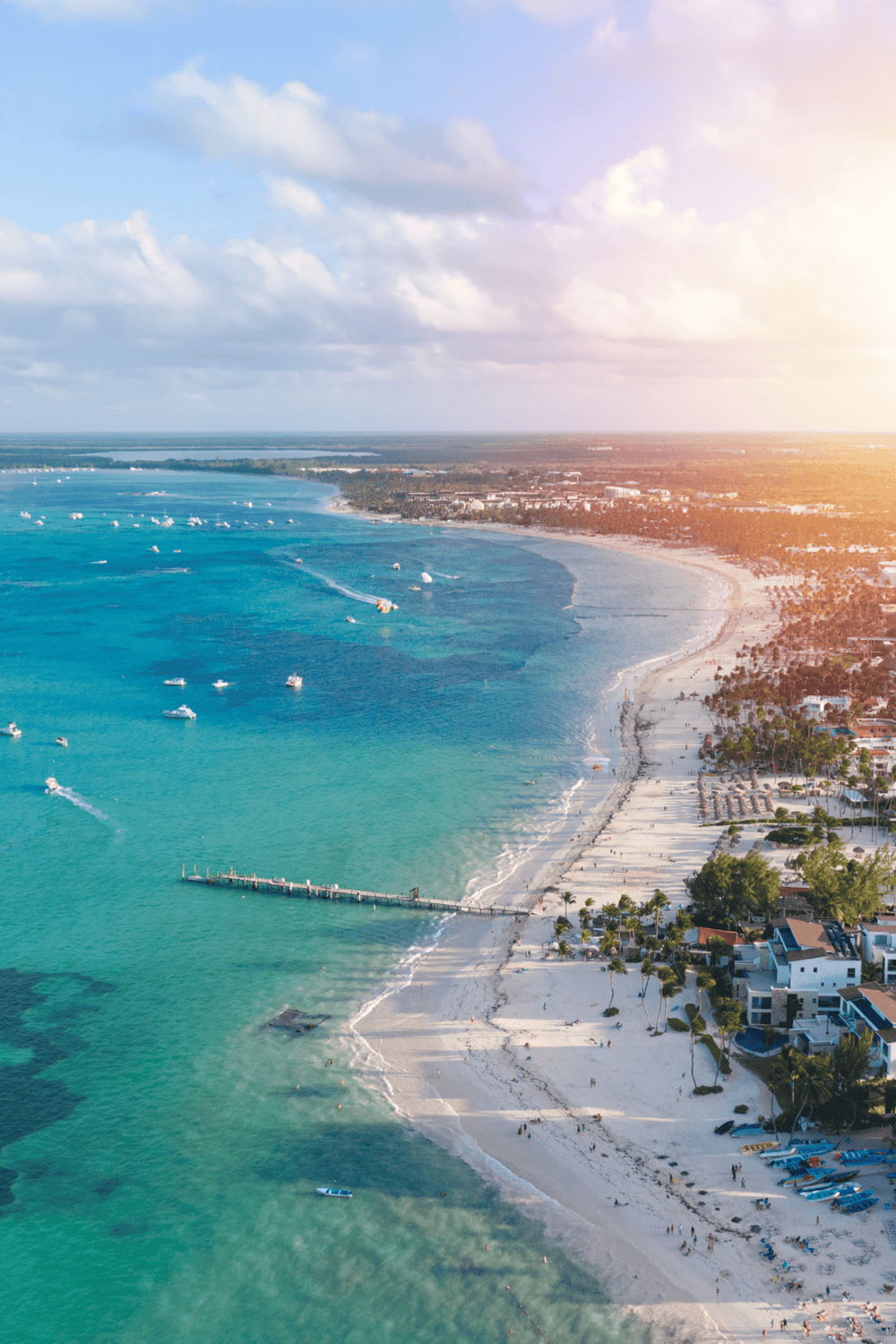 Breathtaking aerial view of a coastal beach destination with turquoise waters and marina.