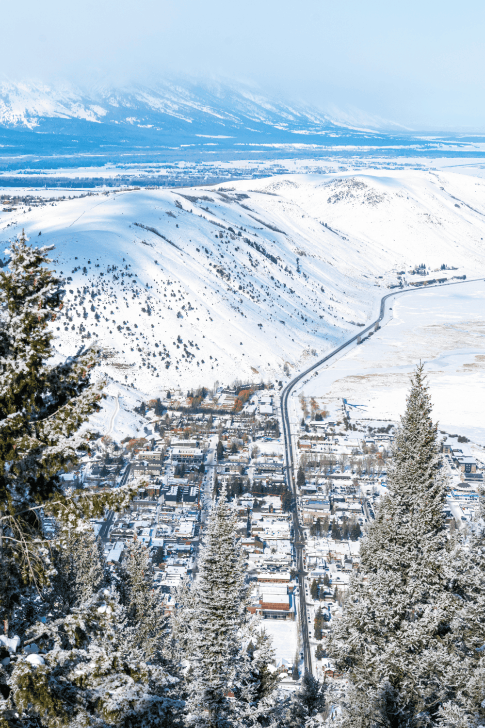 Snow-covered mountain town with scenic views and winding road, ideal for travel and navigation.