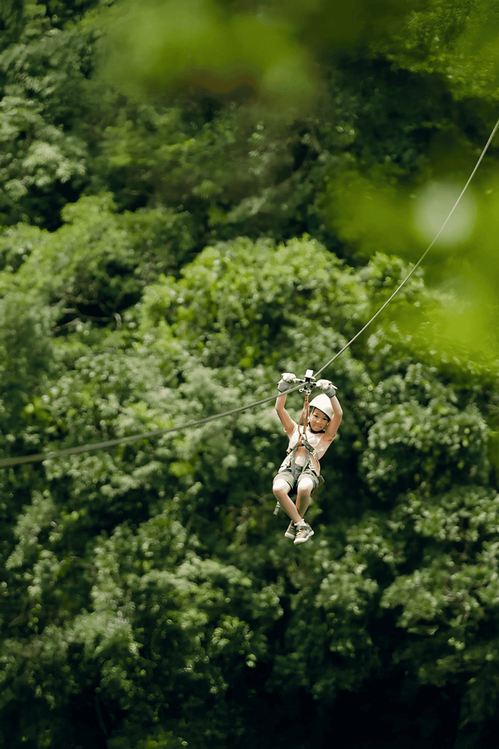 Zipline adventure through lush green forest canopy at QuestForDirections, outdoor thrill experience.