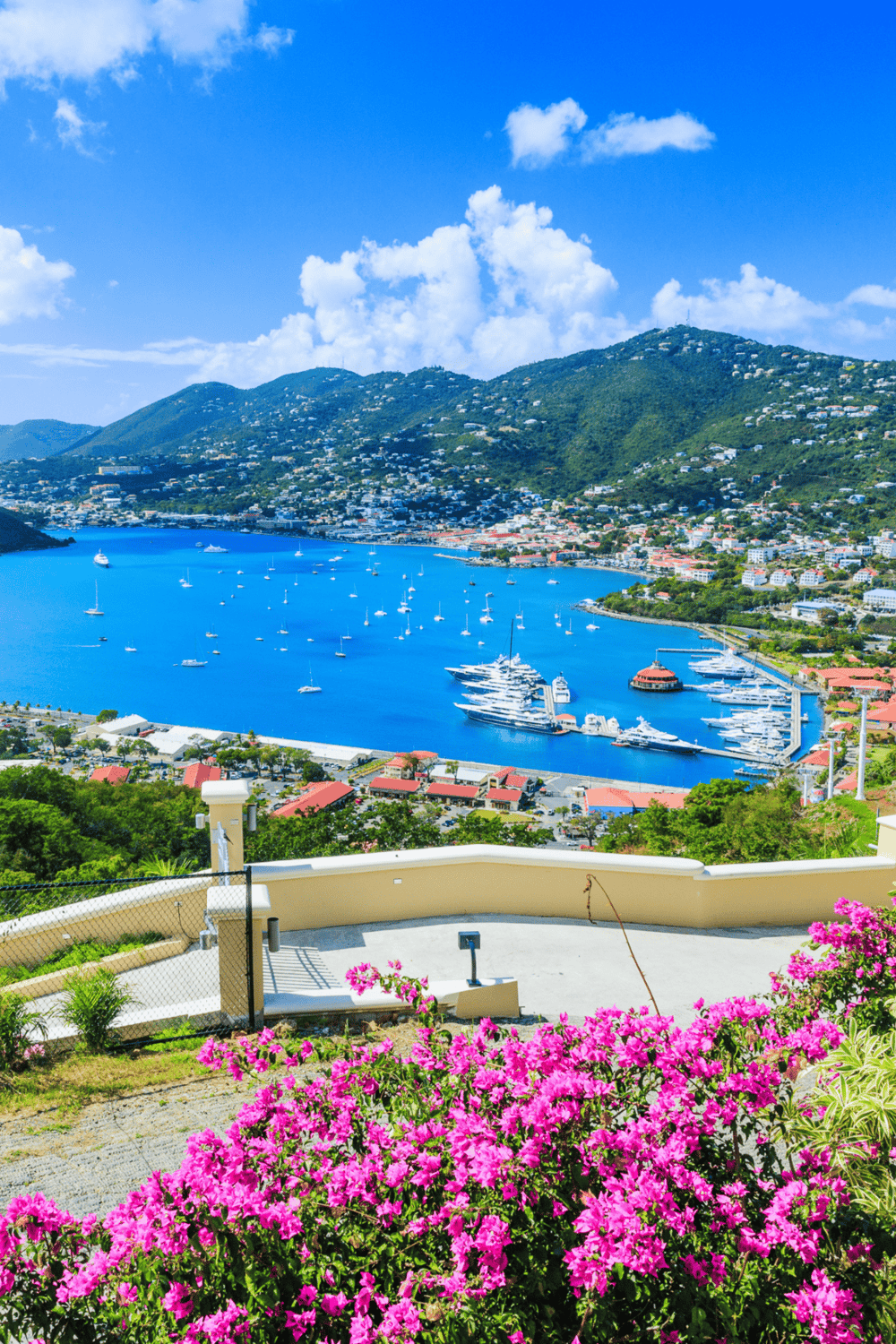 Colorful island harbor with sailboats and lush greenery, perfect for travel and adventure.