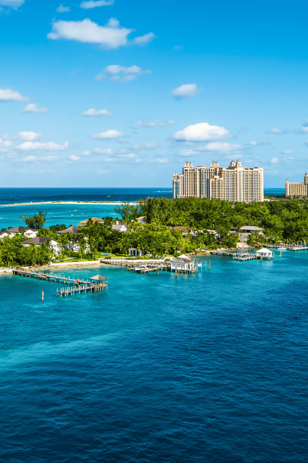 Bright blue ocean with waterfront resorts and tall buildings, Caribbean coastline in warm sunny weather.