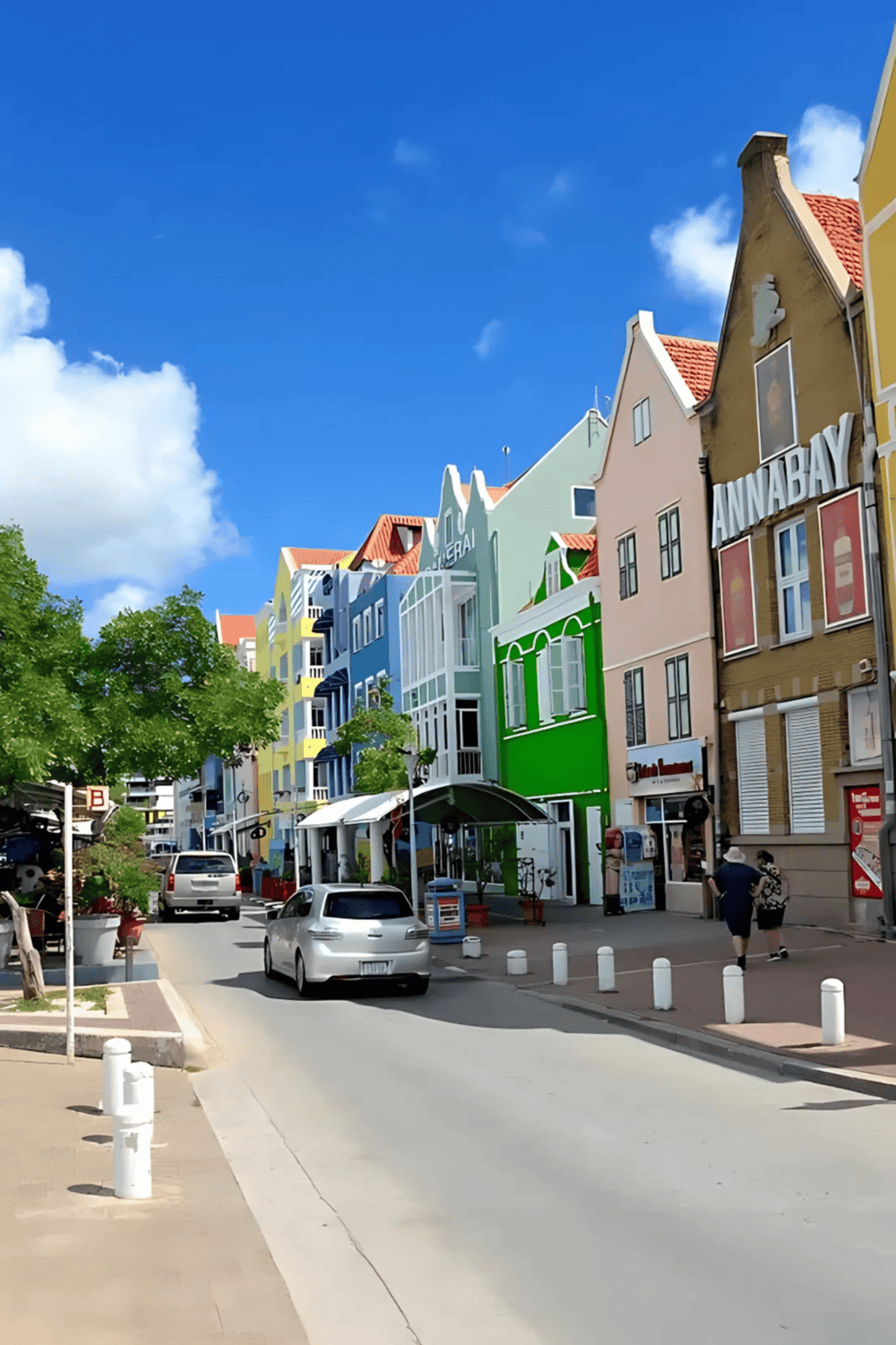 Colorful architecture in a vibrant city street with shops and pedestrians.