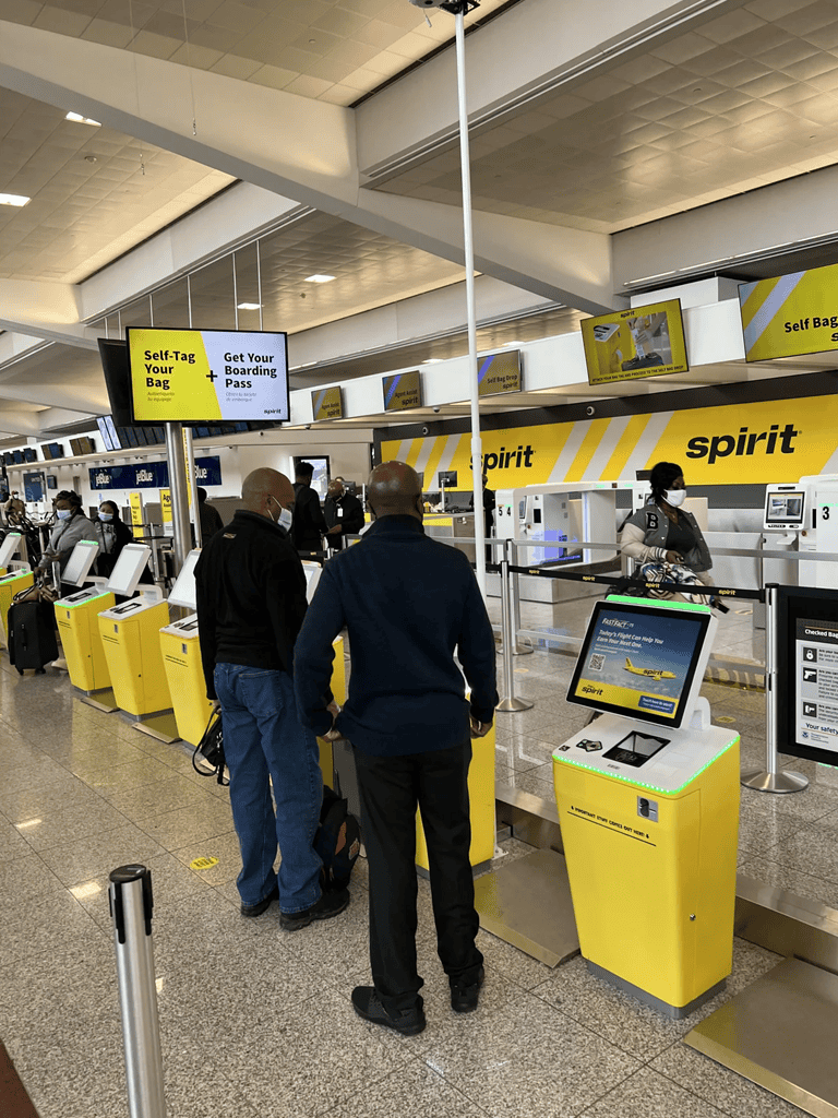 Self Bag Tag Kiosk at Spirit Airlines check-in counter, airport self-service for boarding pass and bag tags.