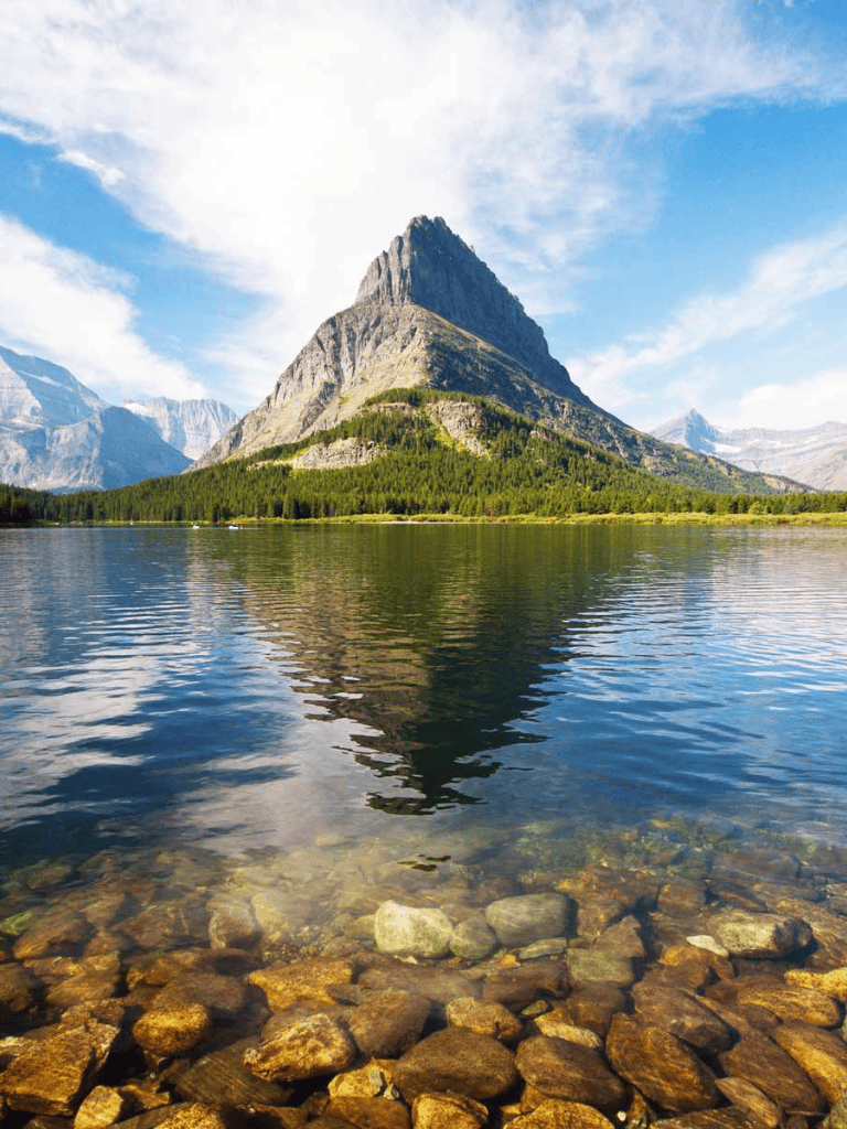 Serene mountain landscape with lake and rocky shoreline, perfect for outdoor adventure and travel planning.