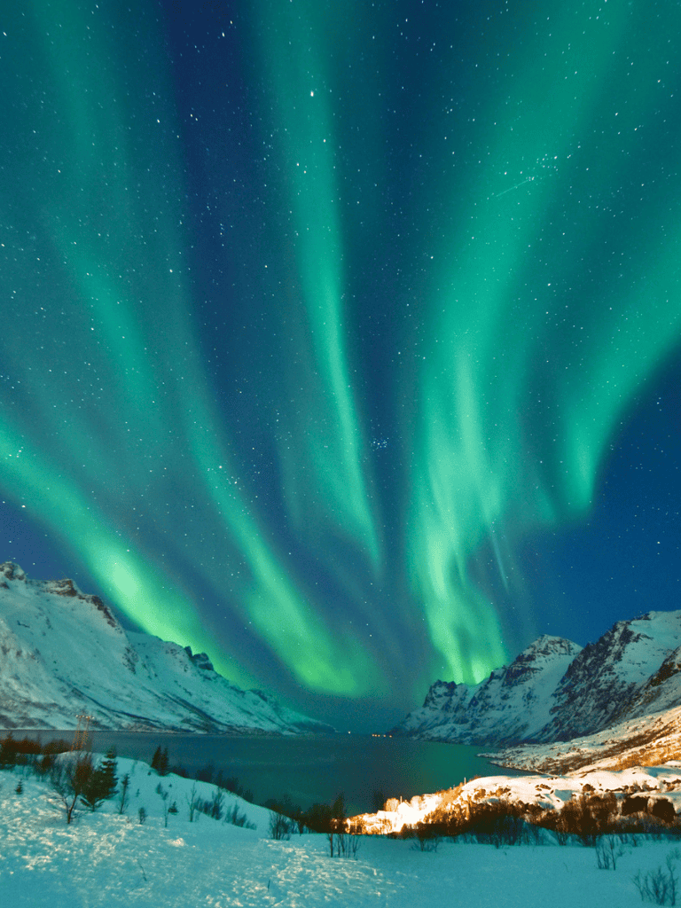 Vibrant northern lights over snow-covered mountains and fjord landscape, breathtaking natural beauty in Arctic Norway.