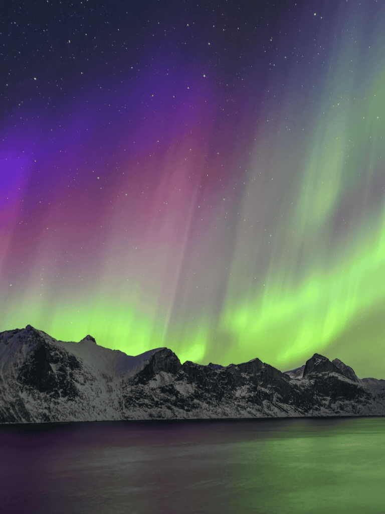 Stunning Northern Lights over mountain landscape in Norway, perfect for travel inspiration.