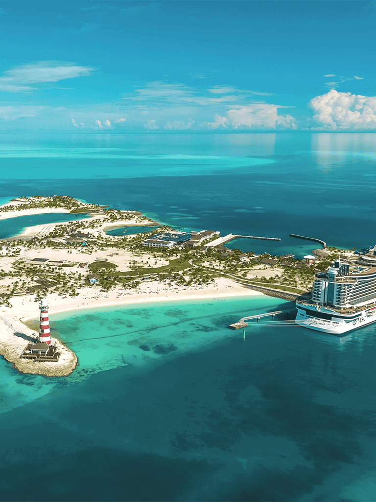 Seaside resort with lighthouse, cruise ship, and tropical beaches in a turquoise ocean.