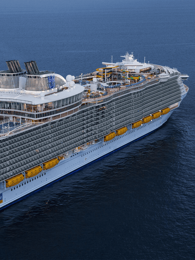 Luxury cruise ship with water slides and modern amenities at sea.